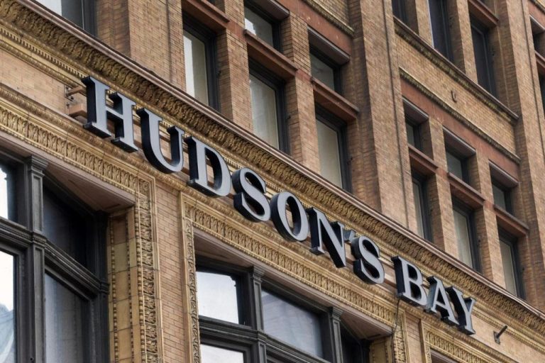 Sign for Hudson's Bay on a historic brick building, highlighting the store's prominent presence in retail and Canadian heritage.