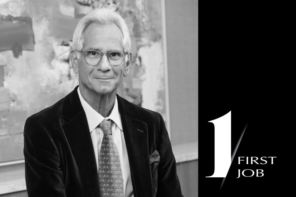 A man in a black velvet blazer smiles confidently, set against an abstract background, with "1 FIRST JOB" text prominently displayed.